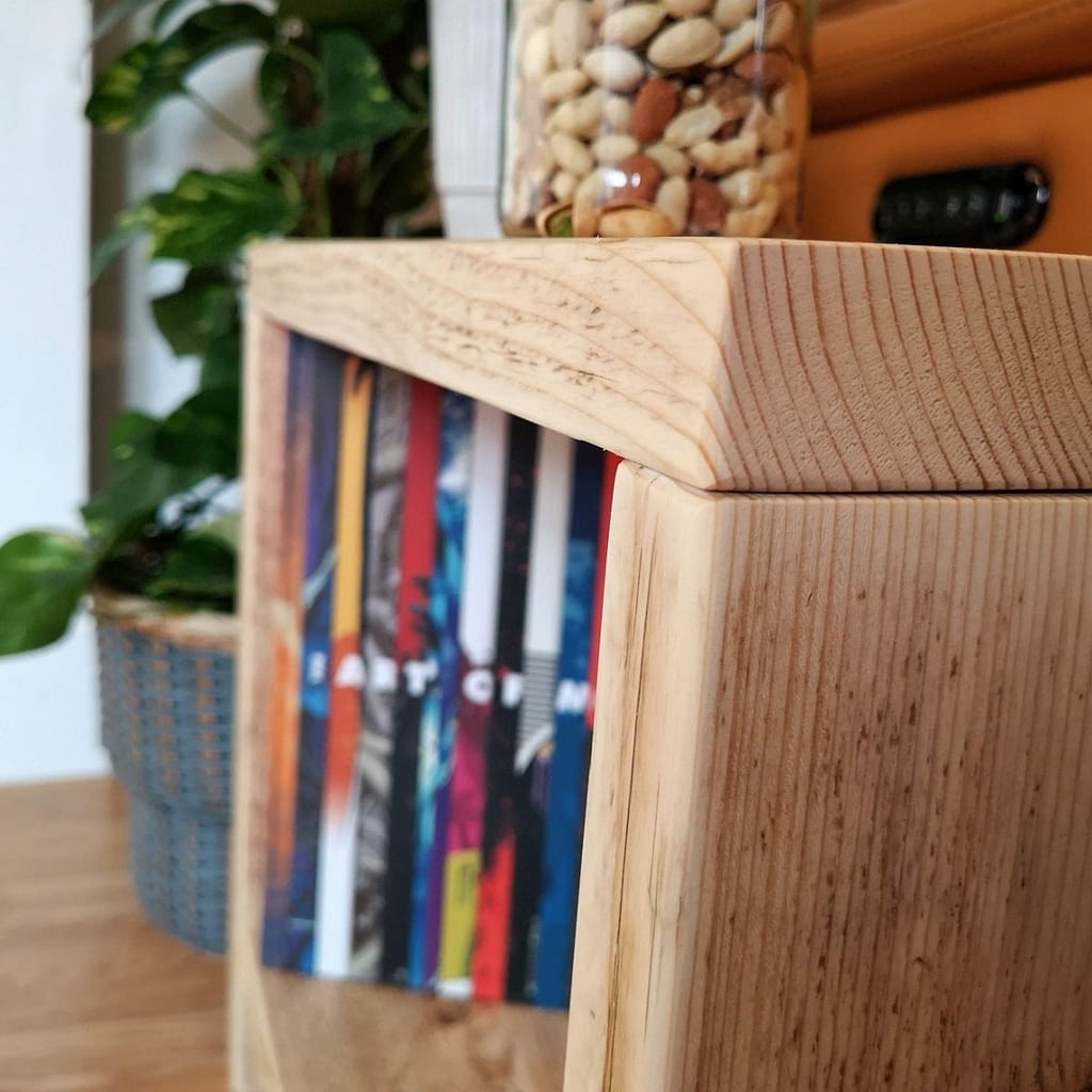 A reclaimed timber side table with pistachios on and a book inside