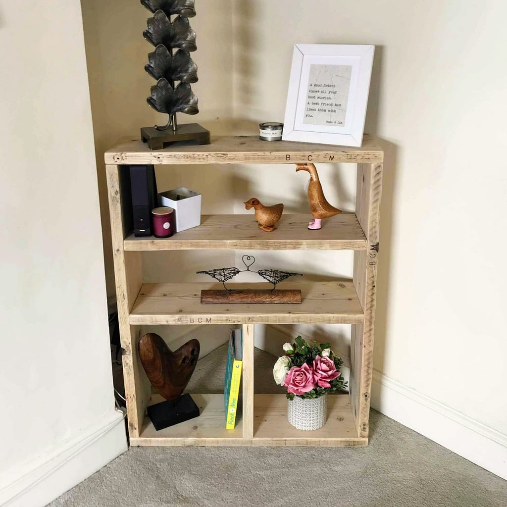 A rustic reclaimed timber bookcase with ornaments on