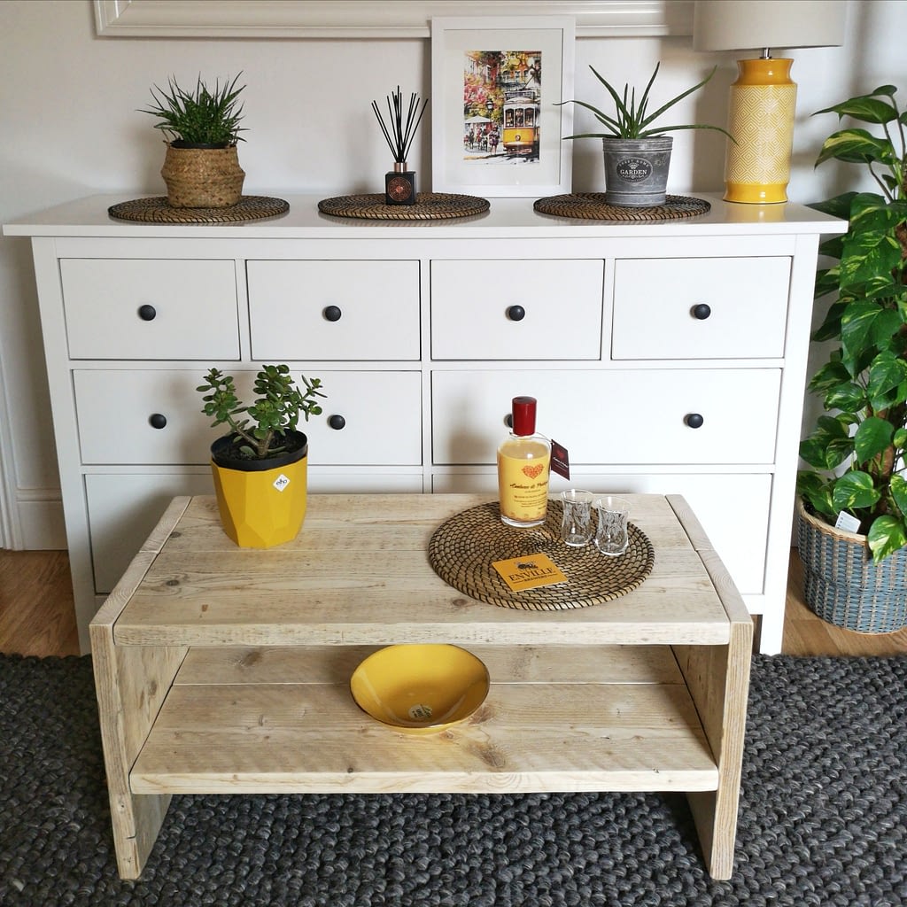 A rustic wood coffee table with liquer and plant