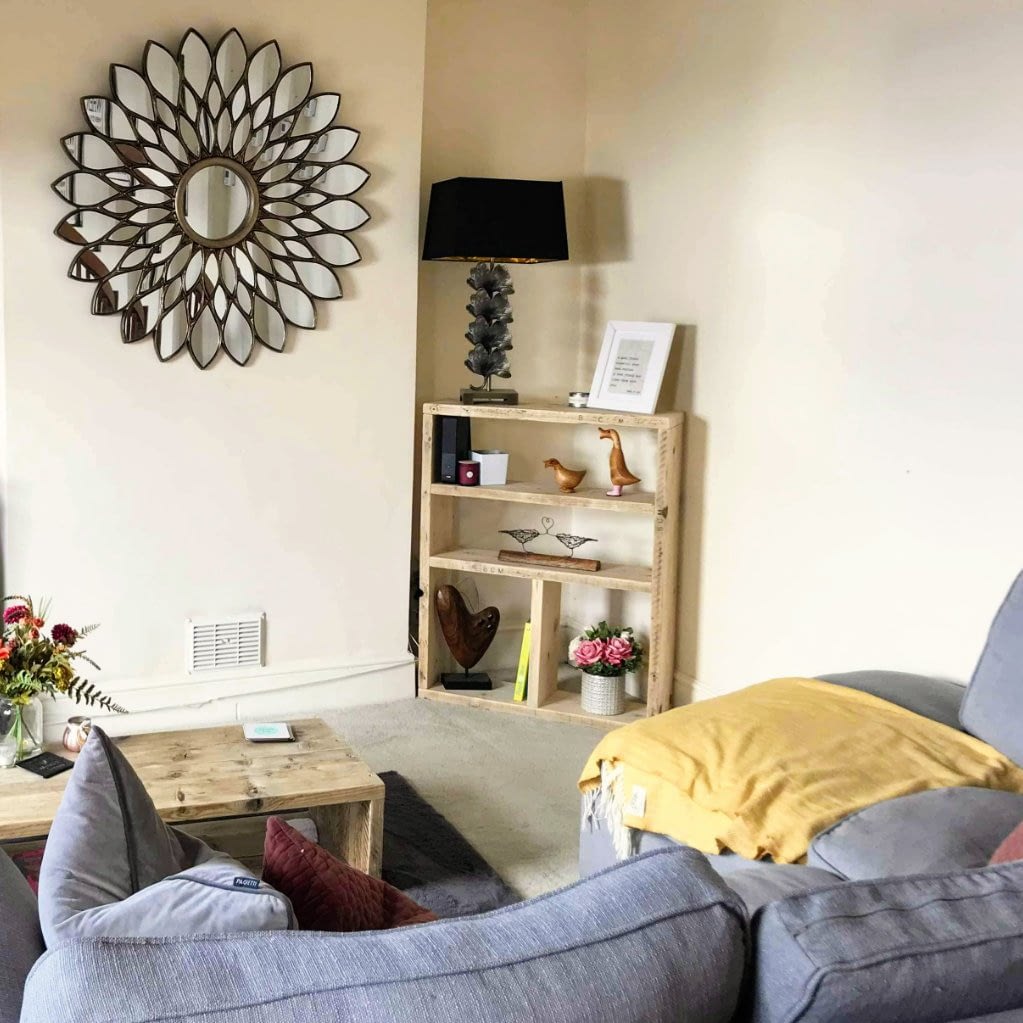 A rustic reclaimed timber bookcase with ornaments on